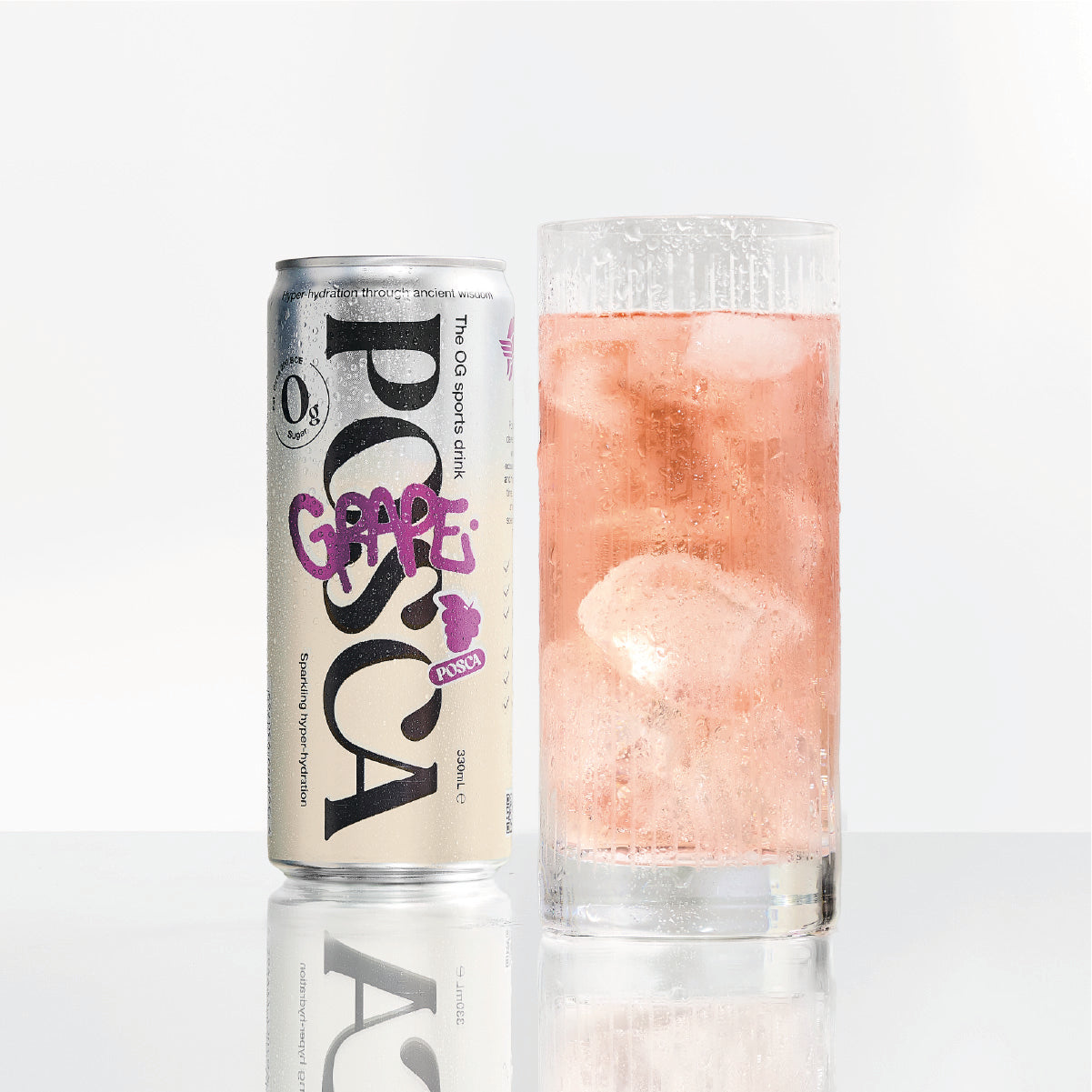 Pocari Sweat Grape flavor can next to a glass of pink drink with ice cubes on a white background